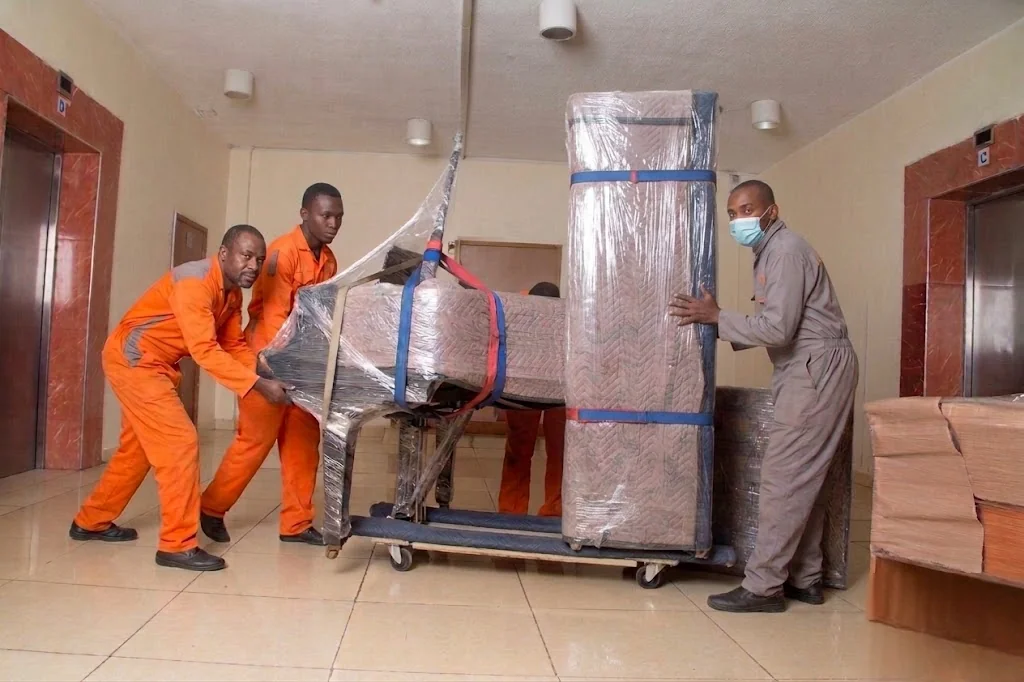 KejaMove crew carefully wrapping and carrying a large item during a Nairobi relocation